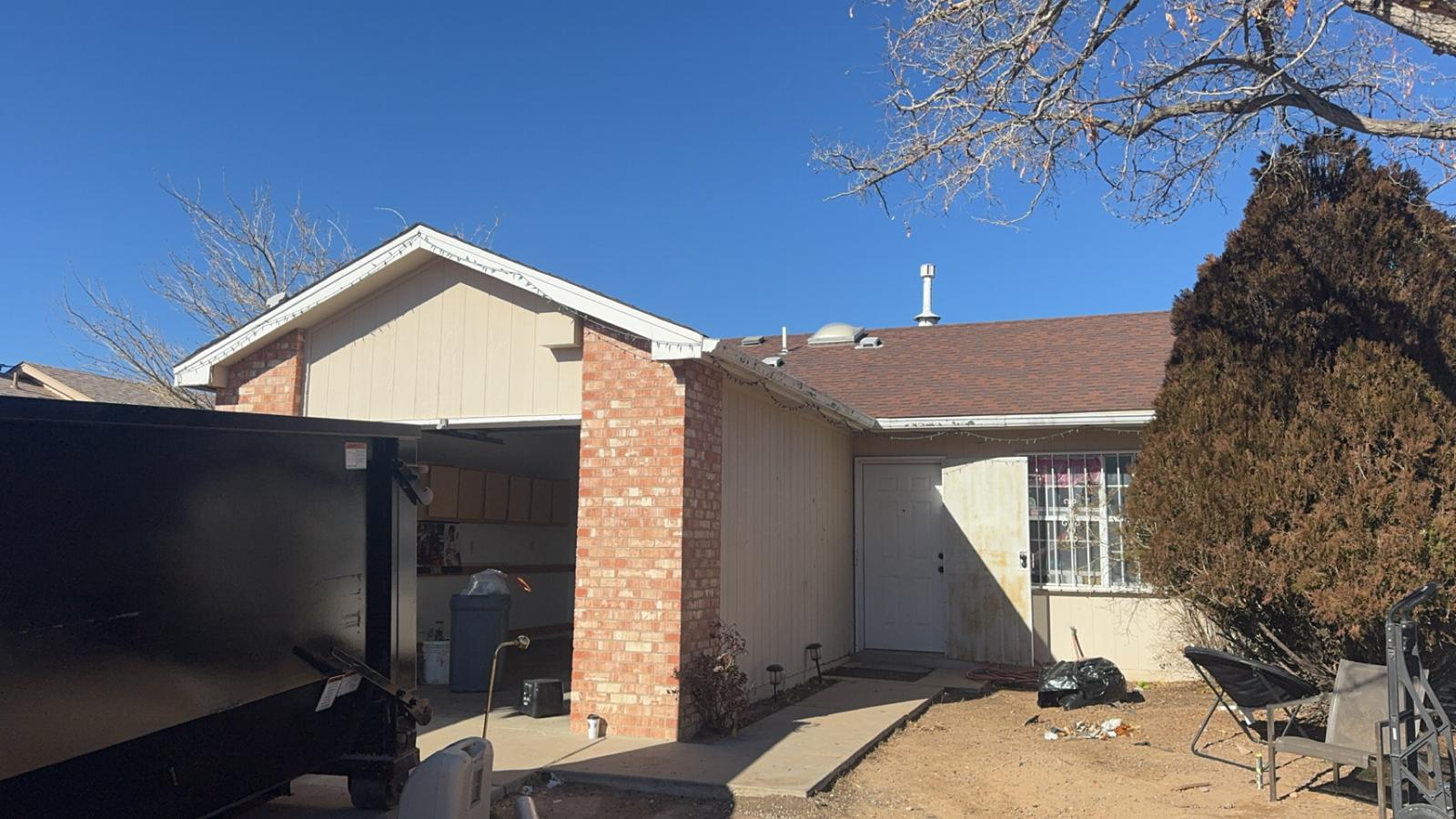 Ranch home mid-renovation with dumpster in driveway