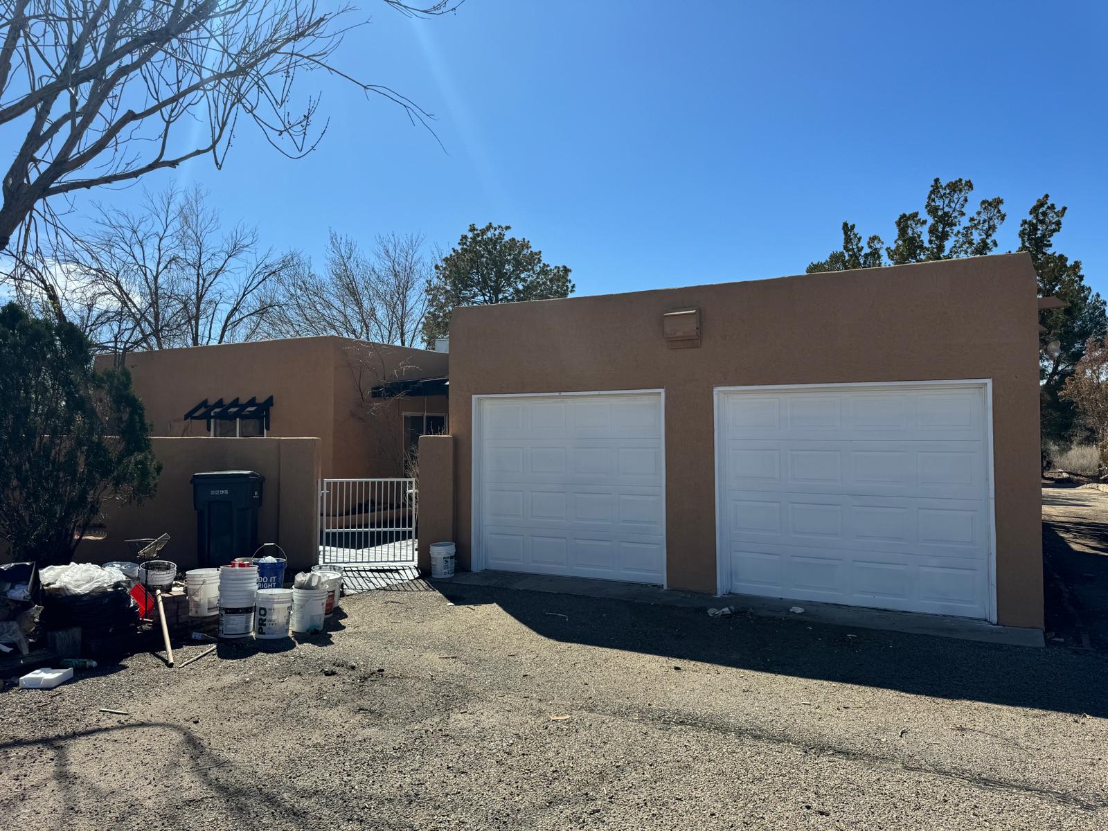 Adobe-style home with newly installed garage doors